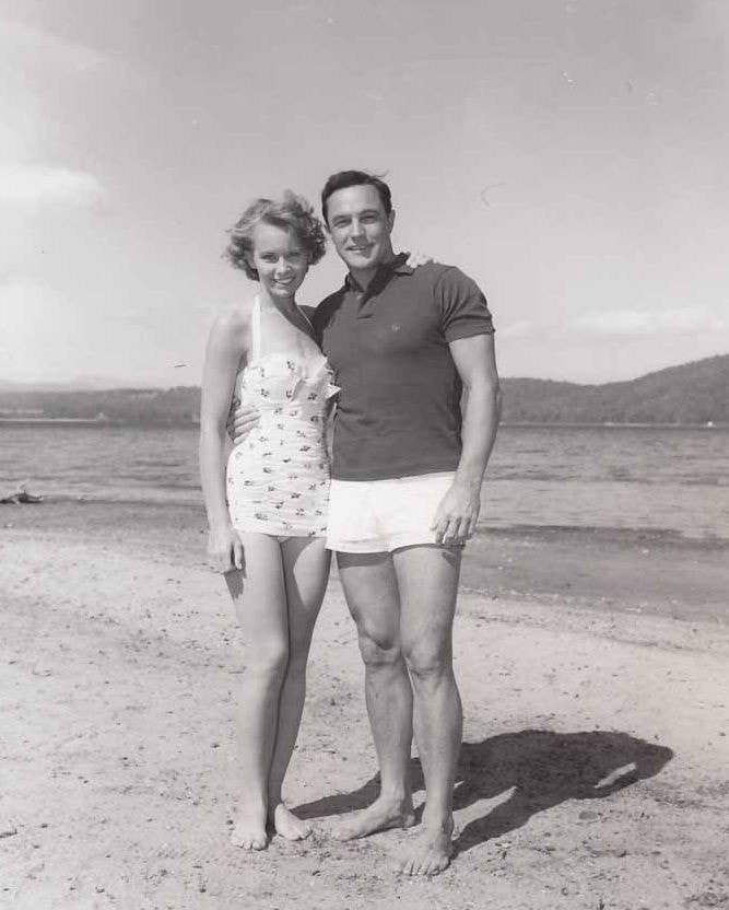 A photo of Gene Kelly and a woman standing on the beach