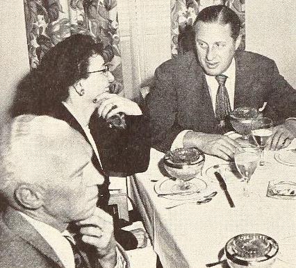 Ann Lewis and two men sitting at a dinner table
